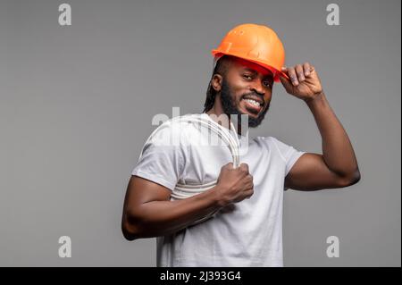 Builder with a wrapped power cable over his shoulder Stock Photo
