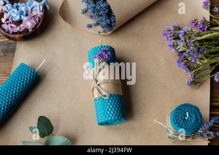 Top view of handmade candle near lavender on craft paper on wooden surface Stock Photo