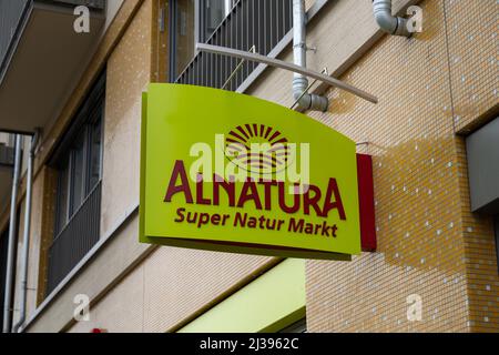 Logo of the Alnatura supermarket next to a building. Organic groceries store with natural products makes advertisement with a board on an exterior. Stock Photo