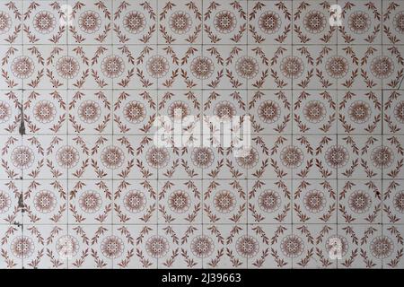 Old tiles on a wall background. Weathered facade of an old building with dirt spots. White square tile pattern backdrop at the exterior of a house. Stock Photo