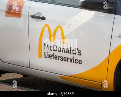 McDonald's delivery service logo on the exterior of a car. Sign printed on the door of the restaurants car. Ordering fast food to your home. Stock Photo