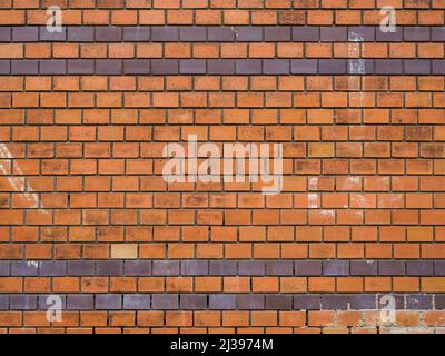 Orange clinker wall background texture with different stones. Dirty weathered surface of an old rough building exterior. Pattern of a fine facade. Stock Photo