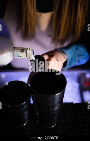 A vertical shot of a female bartender preparing cocktails in a bar Stock Photo