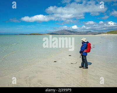 Female tourist on the remote sandy beach of Traigh Mheilein near Hushinish on the Isle of Harris in the Outer Hebrides on a cold May day, Scotland, UK Stock Photo