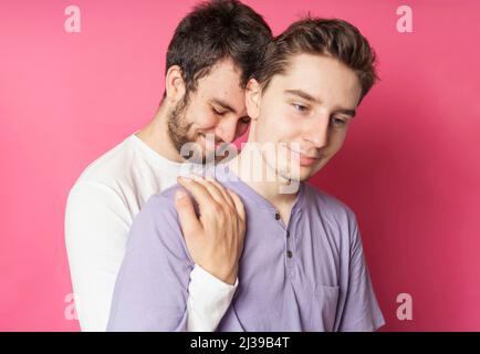 Young gay couple standing together over isolated ping background Stock Photo