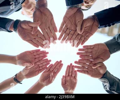 Lets put our hands together. Shot of a group of unrecognizable businesspeople putting their hands together in a circle. Stock Photo