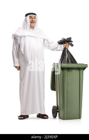 Full length portrait of a happy arab throwing a black plastic bag in a bin isolated on white background Stock Photo