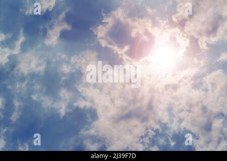 Sun shining through rain clouds. Dramatic cloudscape with halo Stock Photo