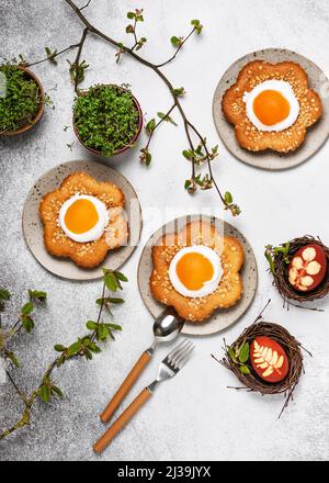 Homemade sweet easter flower shaped cakes with apricot, icing and chopped almond nuts. Stock Photo