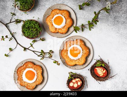 Top view of homemade sweet flower shaped cakes with apricot, icing and chopped almond nuts. Homemade Easter food concept. Copy space. Stock Photo