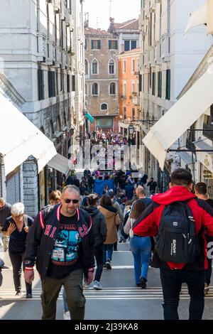 VENICE, ITALY - MARCH 27 2022: Crowds of tourists and locals at the popular market at the Rialto Bridge in the city of Venice Stock Photo