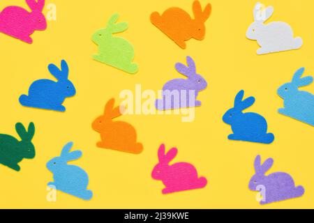 Easter concept. Multi-colored figurines of Easter bunnies on a yellow background. Flat lay Stock Photo