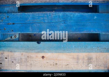 Close-up of a used pallet that has the pine wood colored blue seen from above Stock Photo