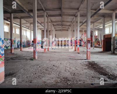 03.29.2021 Warsaw, Poland. Creativity in unconventional places. Obsolete abandoned warehouse hall covered with spontaneous colorful graffiti. . High quality photo Stock Photo