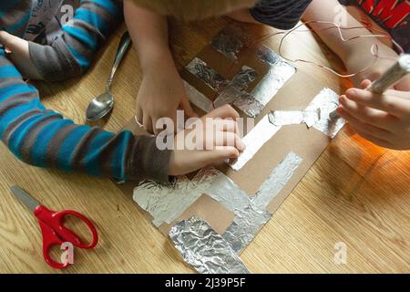 Children's Hands Holding Batteries During Group Science Experiment Stock Photo