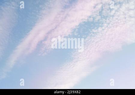 Pastel sky with chemtrails, white and pink and blue shades Stock Photo