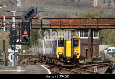 Northern Trains class 156 super sprinter dmu, unit number 156465, passing signal box and approaching Carnforth station on Wednesday 6th April 2022. Stock Photo