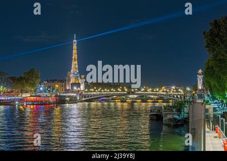 Eiffel Tower and Historic Bridge at Night Seine River and Boat Cruises Charming View Stock Photo