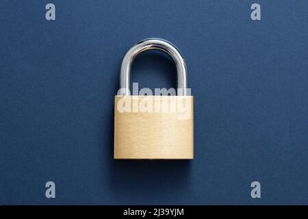 Golden Locked Padlock on the blue background. Stock Photo