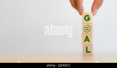 Net zero goal and strategy concept. Decarbonization, low carbon economy for sustainable development. Hand put vertical wooden cubes with “GOAL” text a Stock Photo