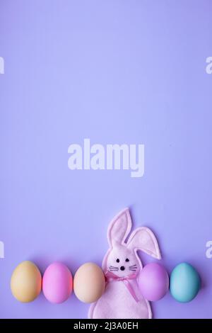Happy Easter concept. Holiday preparation. Easter eggs and bunny isolated on trendy pastel purple background. simple minimalism flat lay top view copy Stock Photo