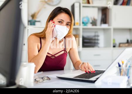 Businesswoman in face mask using phone Stock Photo