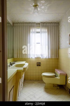 A retro bathroom from the 1960s or 1970s with a yellow theme. This house has since been demolished. Stock Photo