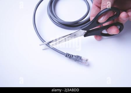 Scissors cut internet cable. Internet shutdown. Cut internet cable. On a white background. Stock Photo