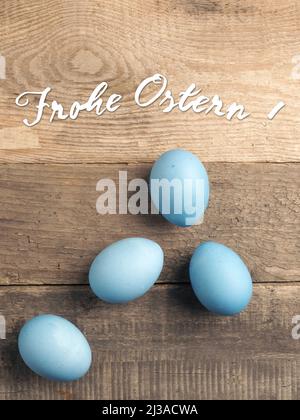 German Happy Easter with naturally colored organic eggs on a rustic table , seasonal background Stock Photo