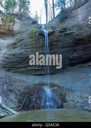 A small waterfall over a rocky wall in the midst of a forest around Zurich, Switzerland Stock Photo