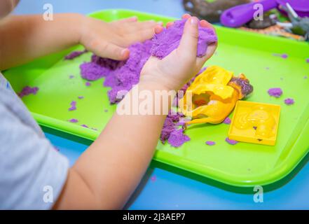 Adult helps child in game with kinetic sand. Art therapy. Relieving stress  and tension. Tactile sensations. Creativity and pleasure. Development of  Stock Photo - Alamy