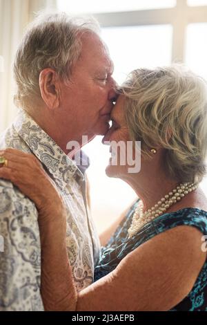 The language of love needs no words. Shot of a senior man tenderly kissing his wifes forehead at home. Stock Photo