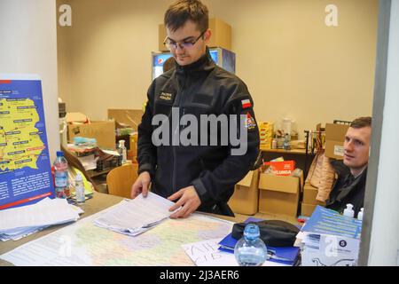 Przemysl, Poland. 3rd Apr, 2022. At the Przemysl station, close to the Ukraine/Polish border, city workers are now required to take shifts, to assist the Ukrainian refugee efforts. Here a Fireman named Patrick is at the information desk. Volunteers do anything needed from referrals to carrying luggage, babies, driving, security and offering a supportive ear, regardless of their job title. (Credit Image: © Amy Katz/ZUMA Press Wire) Stock Photo