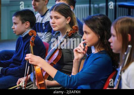 Berlin, Germany. 05th Apr, 2022. Yaroslava Stepanenko from Ukraine (2nd from left) sits with her violin alongside other students at the Carl Philipp Emanuel Bach Music High School in Berlin before a benefit concert in support of the Kruschelnitska Lyceum in Lviv, Ukraine. At the Berlin music high school, eleven particularly gifted children from Ukraine go to school and can continue their education there. (to dpa-KORR ''Mental strength': Ukrainians learn at German music high schools') Credit: Carsten Koall/dpa/Alamy Live News Stock Photo