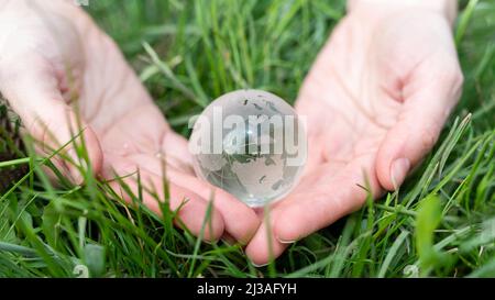 Environment concept. Close up of glass globe in hand on nature background with copy space Stock Photo