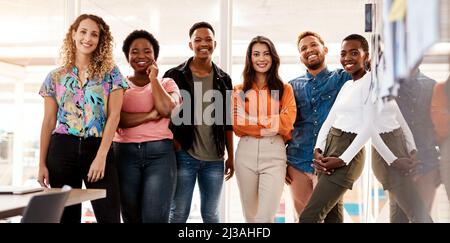 The team you need. Cropped portrait of a group of young designers standing in the boardroom of their office. Stock Photo
