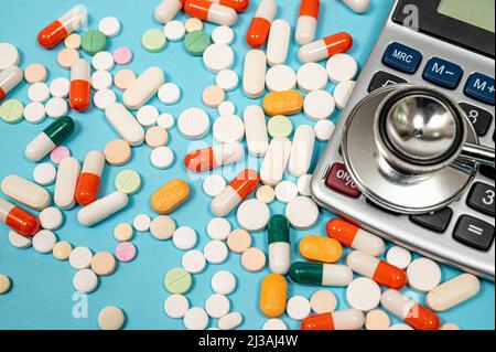 Medical concept with various medicines and calculator on blue background Stock Photo