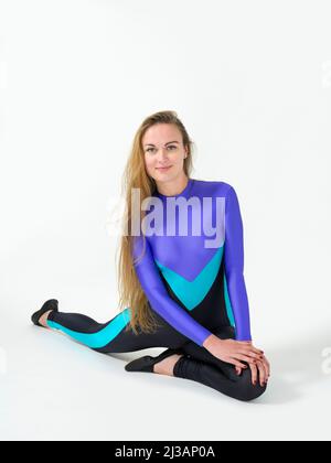 Woman wearing a  catsuit (vaulting dress) doing stretching Stock Photo