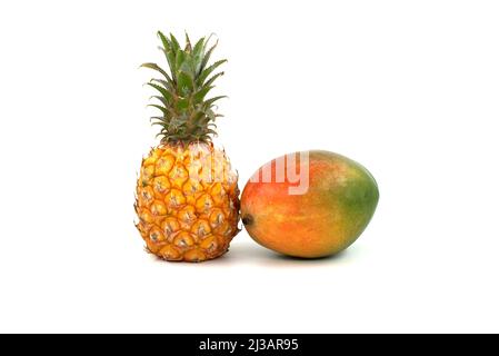 Whole pineapple fruit and multicolored mango isolated on a white background Stock Photo