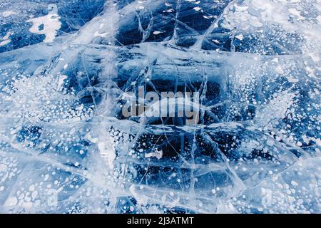 Gas methane bubbles frozen in winter ice of lake Baikal, abstract background. Stock Photo