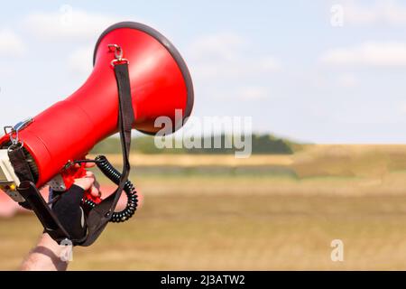 man standing screaming with mouthpiece. Stock Photo