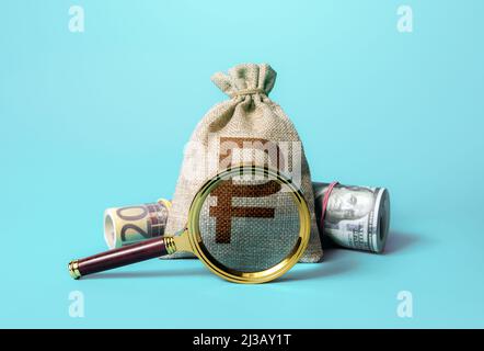 Russian ruble money bag and magnifying glass. Anti money laundering, tax evasion. Deposit or loan terms and conditions. Find investment funds for busi Stock Photo