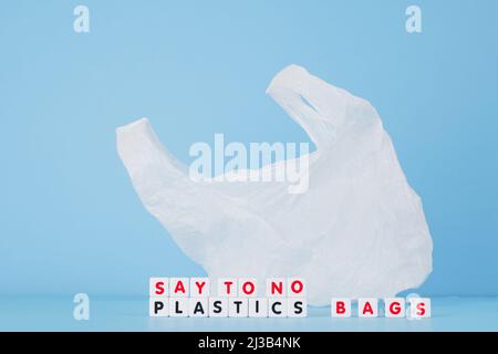 Say no plastics bags words from cubes on the background of a white plastic bag. Plastic free concept. High quality photo Stock Photo