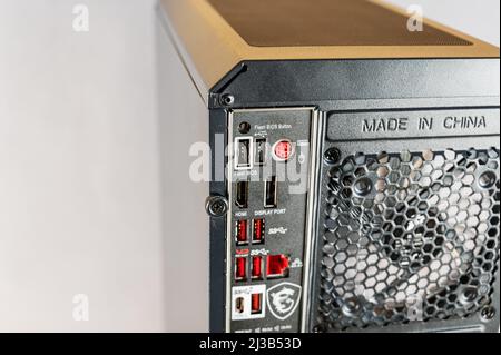 The back of a personal computer system unit. Black case with ventilation grille and connectors for graphics, network and sound card. HDMI and USB corr Stock Photo