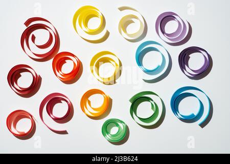 Rainbow colored paper circles on white background. Multicolor spirals pride Stock Photo