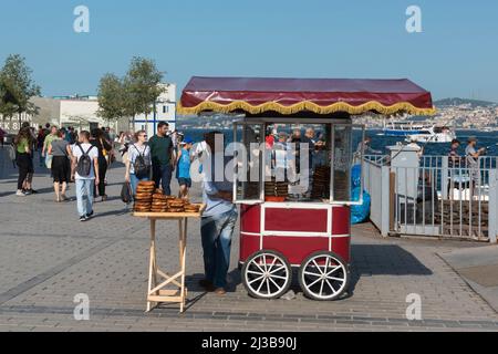 ISTANBUL, TURKEY - JULY 29, 2019: Seller of a traditional Turkish bagel called Simit. Turkish street food. Stock Photo