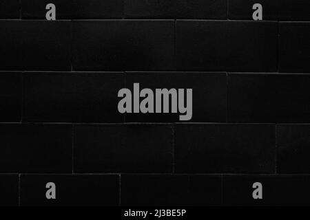 Black tiled wall with brick design. Geometric pattern. Abstract dark background Stock Photo