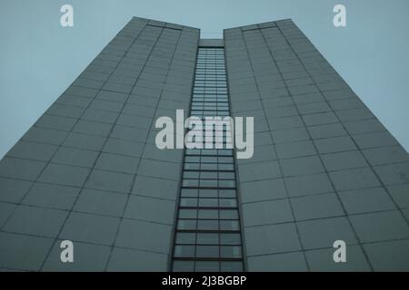 High-rise building on gray day. Architecture details. Surface of wall. Glazing in house. Stock Photo