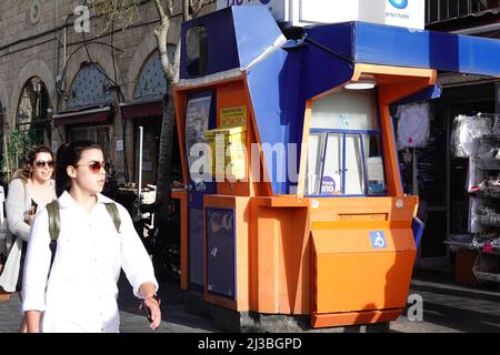 Jerusalem. 6th Apr, 2022. People pass by an automated external defibrillator (AED) installed at a lottery stall in Jerusalem, on April 6, 2022. Israel's national emergency service Magen David Adom (MDA) installed AEDs at phone booths, lottery stalls, and other public locations here to increase the survival rate of people suffering a heart attack. Credit: Wang Zhuolun/Xinhua/Alamy Live News Stock Photo