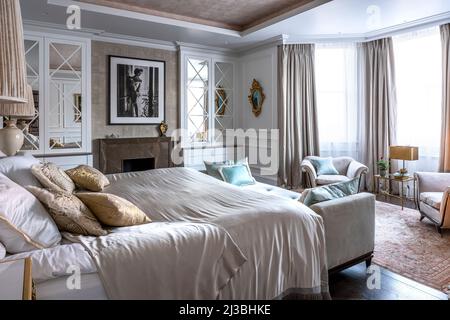 Savoir bed with daybed and 1940s armchairs and bronze table lamp in window, Holland Park, London, UK Stock Photo